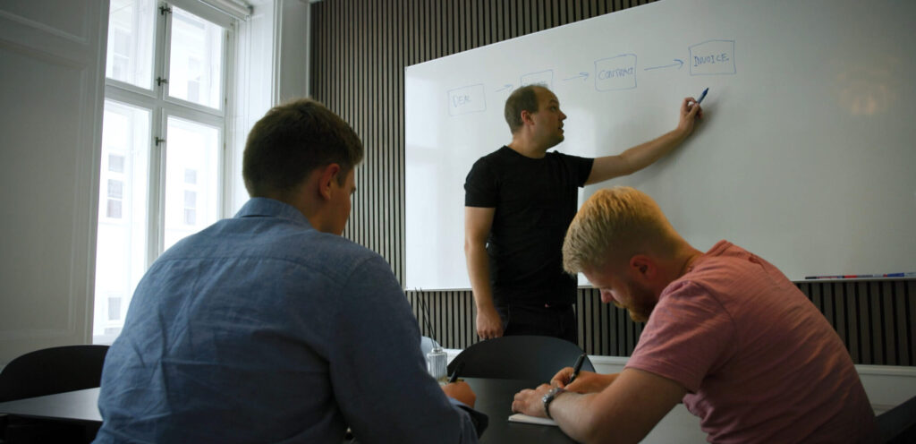 Rådgiver fra ZRM ved whiteboardet under en workshop om AI-implementering